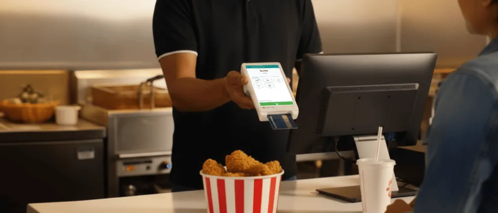 Kitchen cook working next to a RestroGreen Kitchen Display System screen