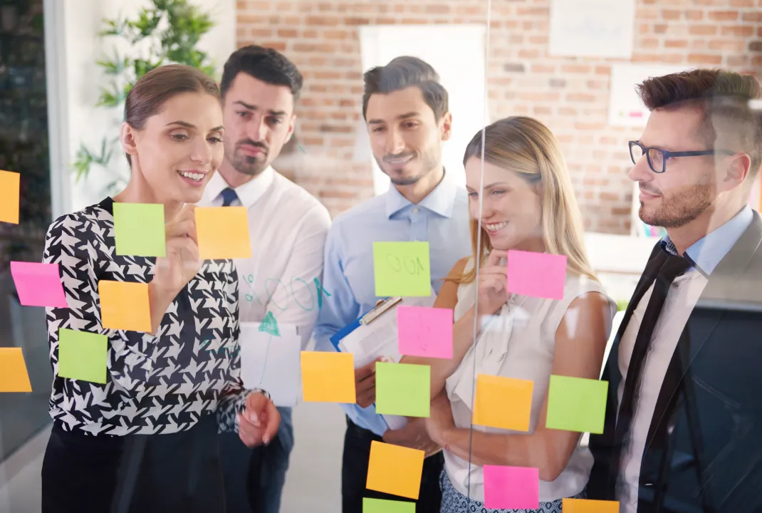 Team planning a marketing campaign with colourful sticky notes on a glass wall